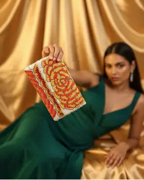 Woman in a green dress holding a colorful fabric swatch against a gold curtain background
