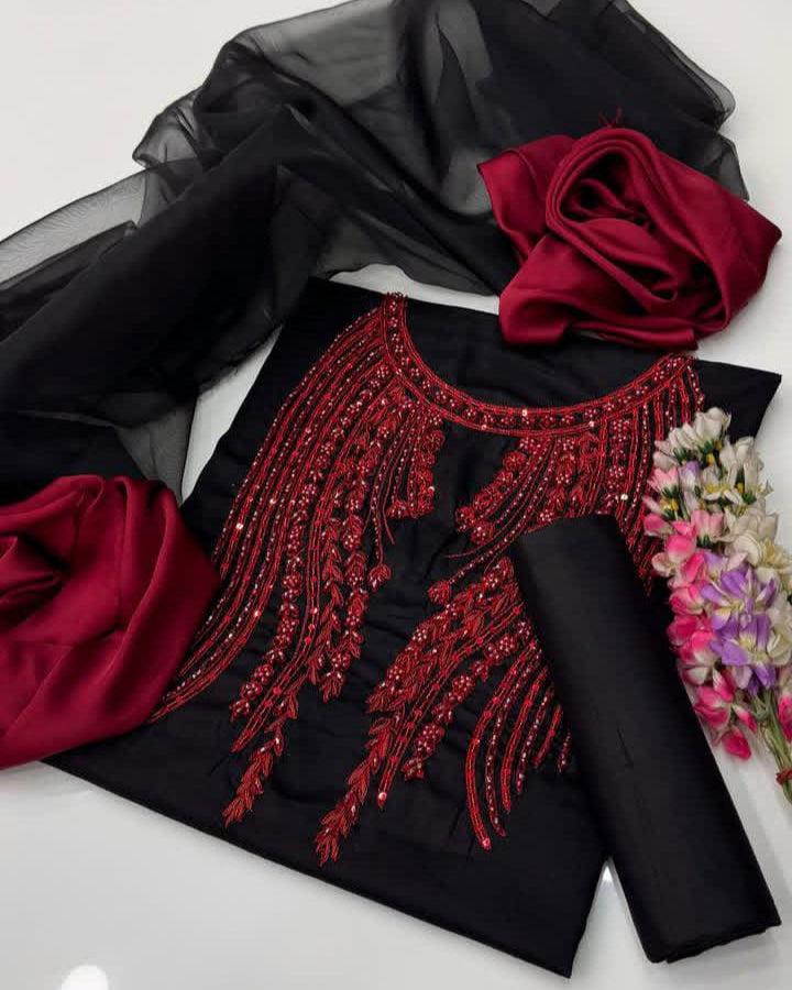 Black fabric with red beaded design and red flowers on a white background